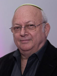 A man with glasses and a beard wearing a black jacket.