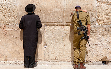 Two men standing next to each other near a wall.