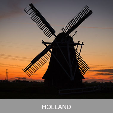 A windmill is silhouetted against the sunset.