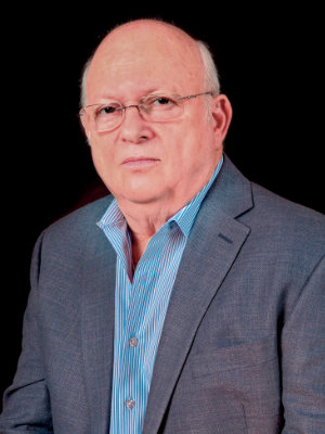 A man in a suit and glasses is posing for the camera.