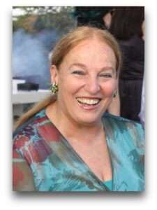 A woman with long blonde hair smiling for the camera.