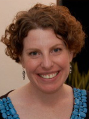 A woman with curly hair smiling for the camera.