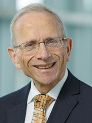 A man in suit and tie smiling for the camera.