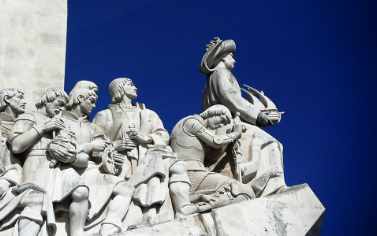 A statue of people sitting on top of rocks.